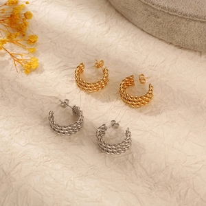 Detailed view of twisted weave C-shaped earrings in gold and silver stainless steel