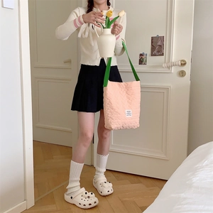 Quilted heart pink shoulder bag with green straps paired with a preppy style outfit