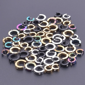 Detalle macro de varios pendientes huggie de acero inoxidable en oro plata y colores arcoíris
