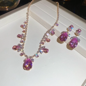 Détail de parure de bijoux élégante en or avec collier et boucles d'oreilles rose zircon