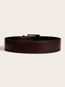 Close-up of wide dark brown leather belt with decorative stitching and bronze buckle