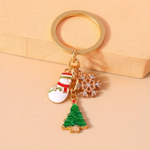 Detail of Christmas keychain with enamel snowman, green tree and sparkling snowflake
