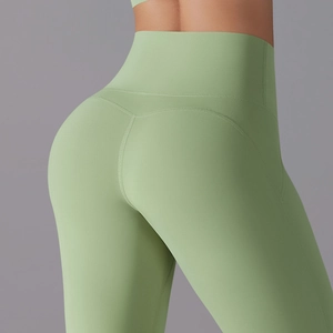 Detail of high waisted yoga leggings in sage green featuring back V-shape lifting seams