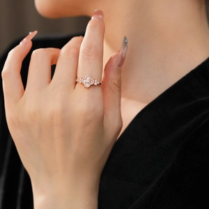 Macro shot of rose gold flower ring with white mother of pearl and zircon stones on finger