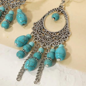 Detailed close-up of Bohemian retro silver earrings with turquoise beads and tassels