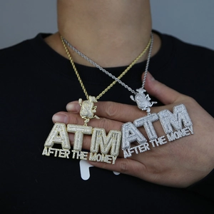 Macro detail of ATM After The Money iced-out pendants in gold and silver finish