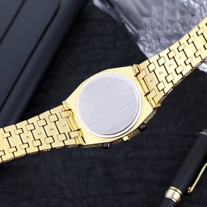 Close-up of golden watch backplate with iced-out bezel and numbered bracelet links