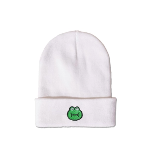 Detail of white knit beanie featuring green embroidered frog motif on folded brim