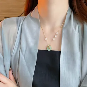 Élégant collier feuilles de ginkgo doré avec anneau jade vert et détails perlés