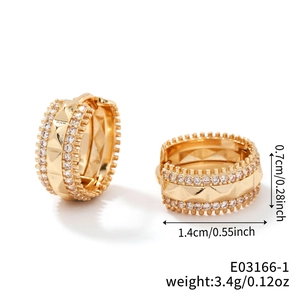 Macro shot of gold hoop earrings with micro-pave cubic zirconia and geometric patterns