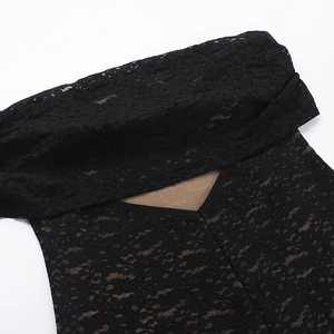 Detail of delicate black lace fabric with sheer floral patterns and off-shoulder neckline