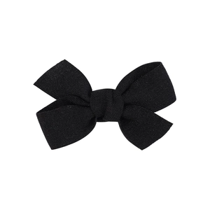 Detailed view of a handmade black fabric bow hair clip with textured weave design