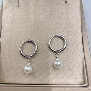 Close-up of minimalist silver hoop earrings with round white pearl pendants on display