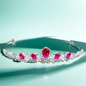 Detail of luxury bridal crown with red teardrop zircons and shimmering silver crystals