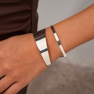 Close-up of irregular silver-finish metal bracelet set with polished geometric texture