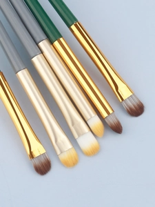 Detail view of eye makeup brushes with dual-tone handles and golden metal ferrules