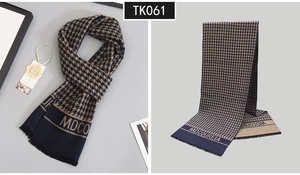 Detail of wool blend houndstooth scarf in navy and camel with luxury fringe and logo