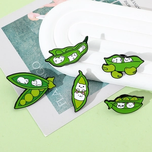Detailed close-up of colorful pea pod enamel cat pins on a ceramic tray display
