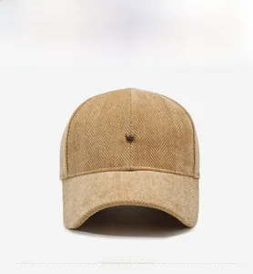 Detail of khaki corduroy baseball cap with a gold crown emblem and textured fabric