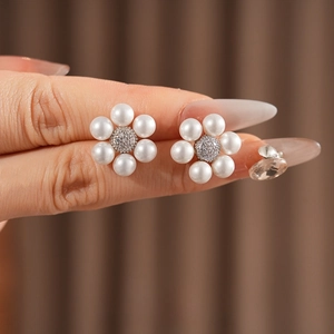 French vintage flower pearl earrings with sparkling zircon centers shown on finger
