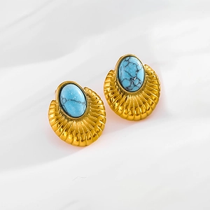 Macro shot of vintage gold drop earrings featuring elegant blue turquoise stone texture