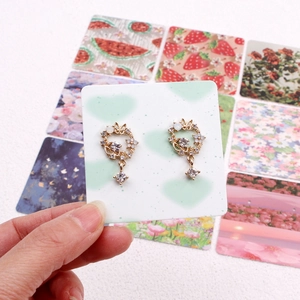Elegant gold floral wreath earrings with rhinestones and opal on display card
