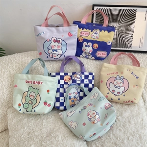 Flat lay of multiple cute canvas tote bags with various cartoon prints on white plush surface