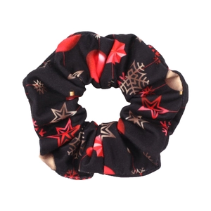 Close-up of black Christmas scrunchie with festive red and gold snowflake patterns
