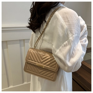 Close-up of apricot PU leather crossbody bag featuring classic V-quilted pattern and gold chain