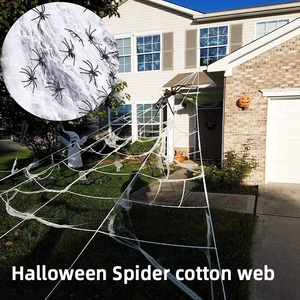 Outdoor Halloween decoration featuring a white spider cotton web with black plastic spiders
