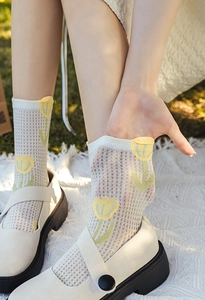Close-up of hollow mesh floral socks with yellow tulip pattern and Mary Jane shoes