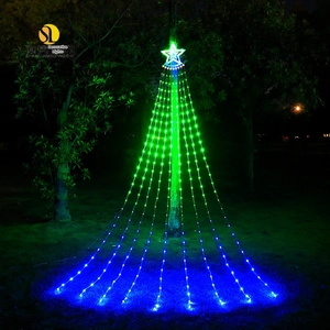 Detail of LED star waterfall lights with colorful gradient hanging on a tree in a dark park