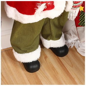 Detail of Christmas Santa doll showing green knit trousers and black boots on wood floor