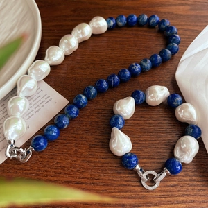 Baroque pearl and lapis lazuli jewelry set with necklace and bracelet on wood