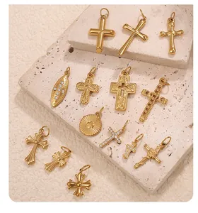 Detail of 18K gold-plated stainless steel cross pendants with crystal inlays on stone