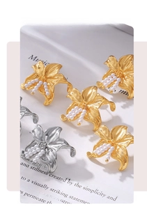 Macro shot of lily flower earrings with white pearls in gold and silver finish