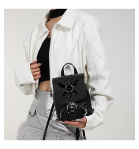 Vue détaillée du mini sac à dos en cuir noir avec découpe papillon et anneaux argentés