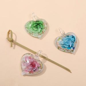 Detail of heart-shaped glass pendants with floral patterns and gold foil accents