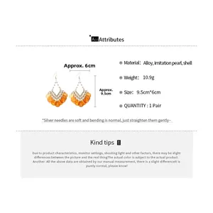 Detail of bohemian orange shell tassel earrings featuring alloy hooks and pearls