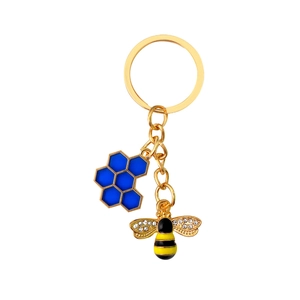Golden keychain featuring a blue honeycomb charm and a sparkling honey bee pendant