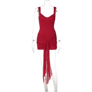 Dettaglio dell'abito in pizzo rosso con scollo a V e allacciatura decorativa sulla parte frontale