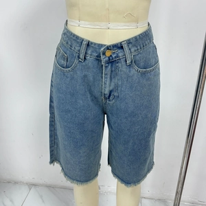 Detail view of high-waisted blue denim shorts with a stylish frayed hem finish