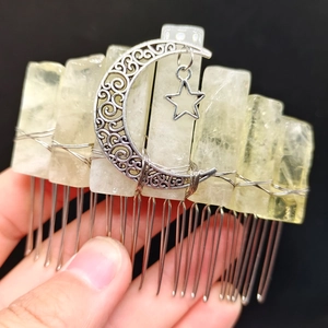 Detail of handmade natural crystal hair comb with metallic moon and star charm