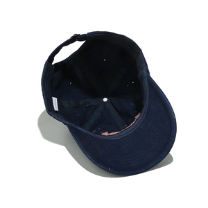 Detail view of navy cotton baseball cap interior with stitching and adjustable metal buckle
