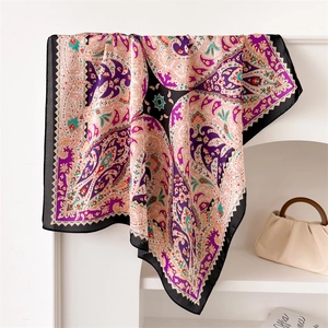 Detailed view of square paisley silk scarf draped over a stand with elegant texture