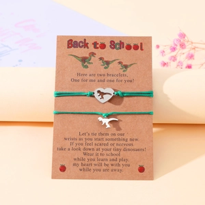 Detail showing two green braided bracelets with dinosaur heart pendants on a Back to School card