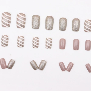 Faux ongles élégants champagne et rose avec paillettes et motifs à rayures obliques