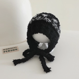 Detailed knit texture and woven patterns on black plush balaclava with tie-up straps