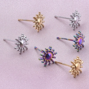 Detailed view of sun-shaped stainless steel earrings in gold, silver, and iridescent tones