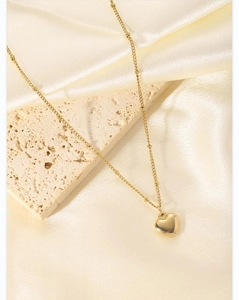 Detail of 18K gold heart pendant on a delicate beaded chain over elegant silk